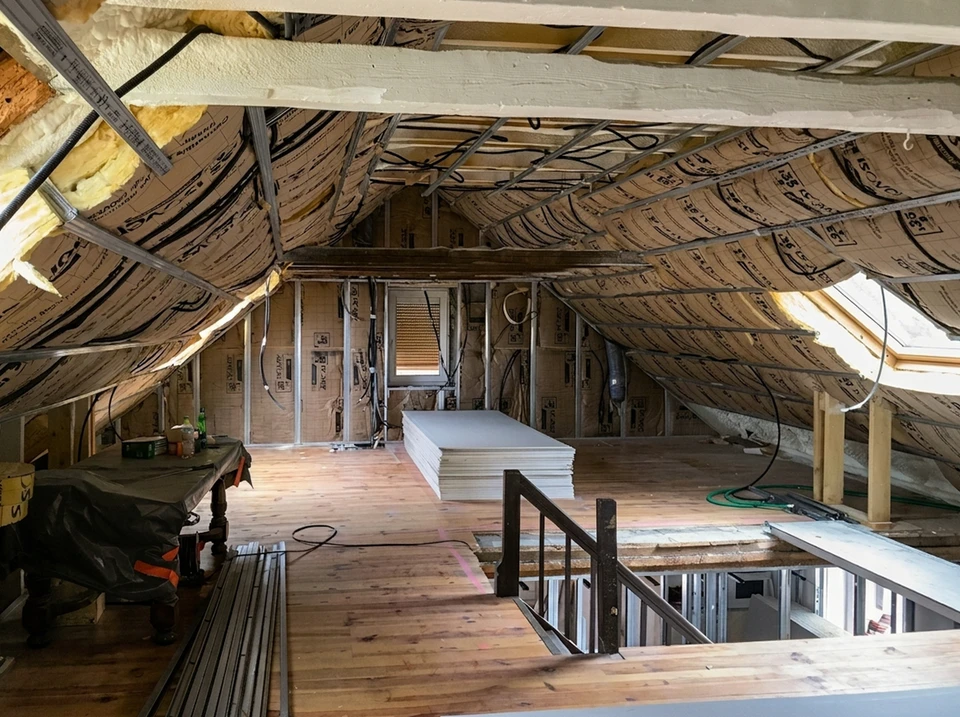 Ouvrier en bâtiment installant de l'isolation thermique dans une construction résidentielle
